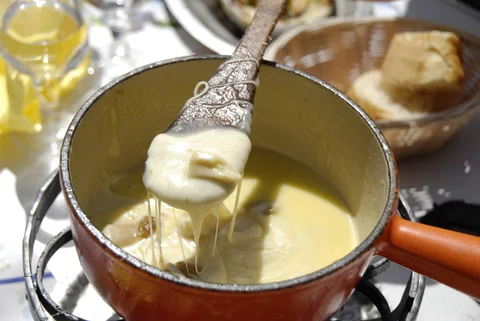 Bread dipped into a pot of cheese fondue